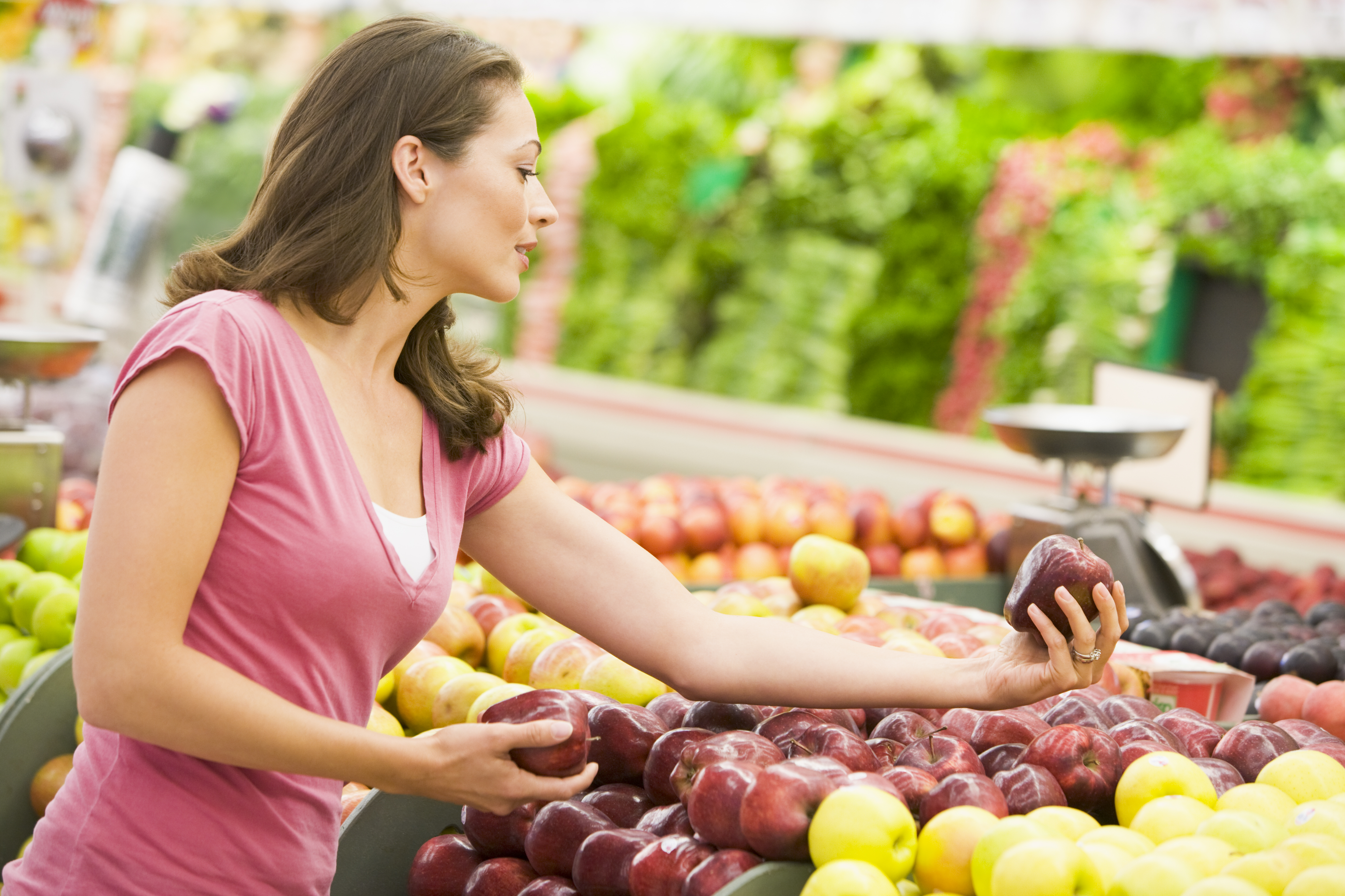 Кидать фрукты. Женщина выбирает овощи в магазине. Женщина на рынке выбирает овощи. Женщина выбирает фрукты в магазине. Девушка выбирает овощи.
